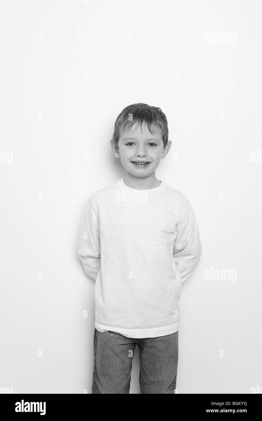 Kleiner Junge steht durch die Wand in schwarz / weiß Stockfoto