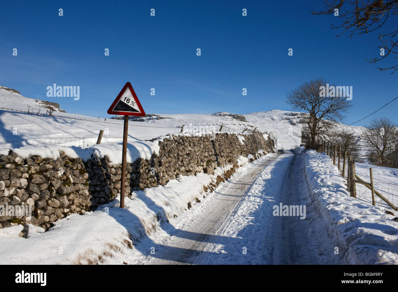 Eine eisige, schneebedeckte Straße mit 16 % Steigung Warnzeichen Stockfoto