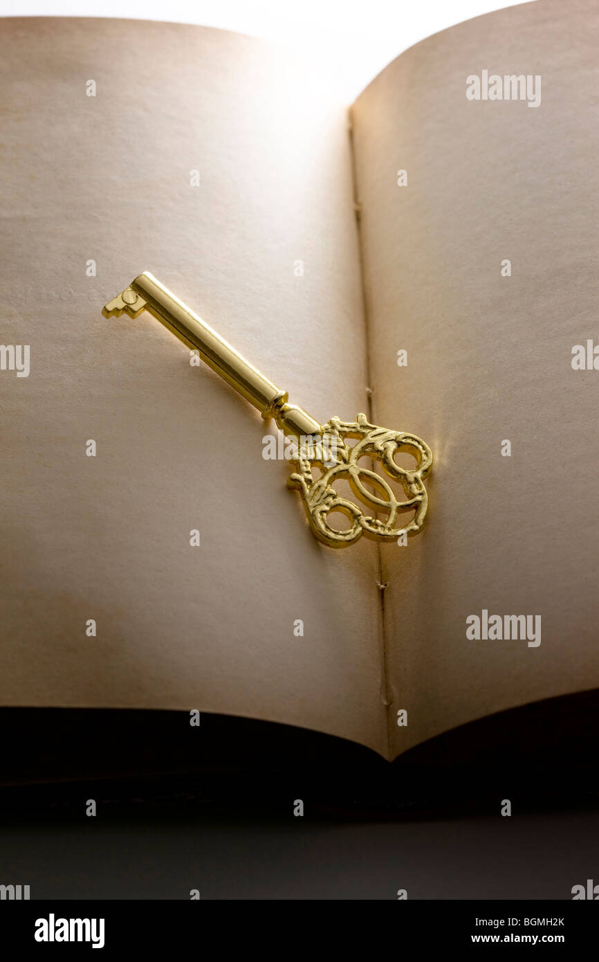 Gold Key in Open Book ruhen Stockfoto