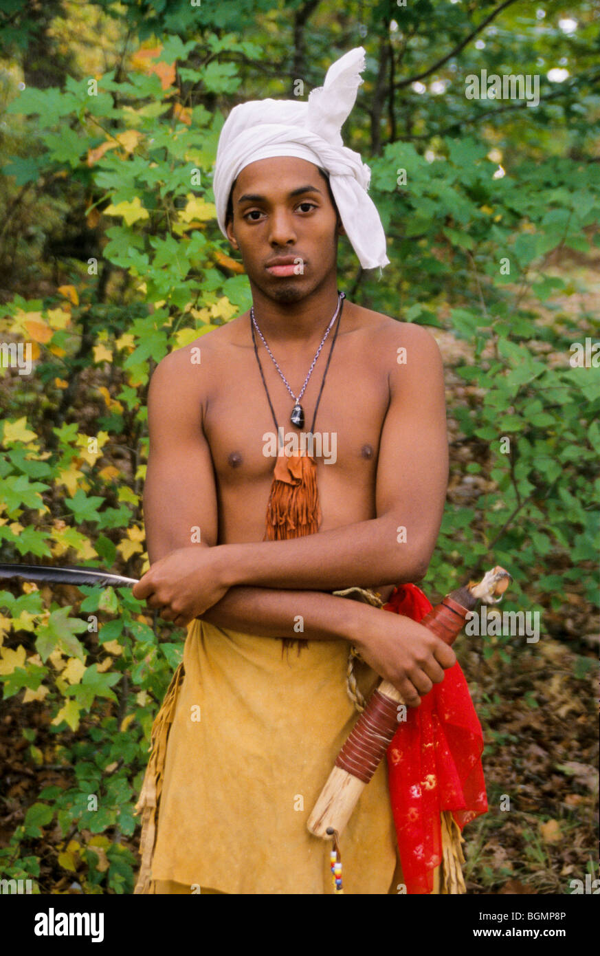 Der junge Cherokee-Mann, der in traditionellen Buckskin-Leggings und Breechcloth gekleidet ist, trägt auch den traditionellen Turban, der in den frühen 1800er Jahren, NC, üblich war Stockfoto