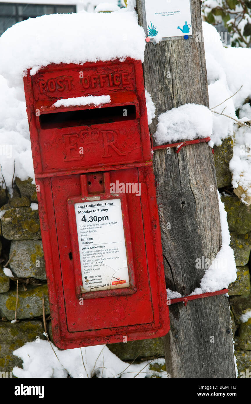 Rostigen Briefkasten in einem englischen Dorf mit Schnee bedeckt Stockfoto