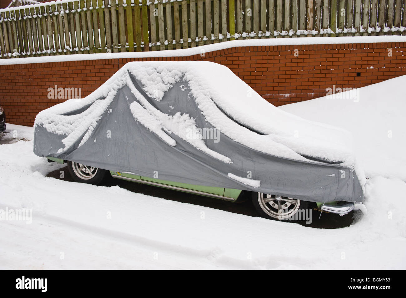 VW Oldtimer mit Schutzhülle bedeckt im Schnee bei Newport South Wales UK Stockfoto