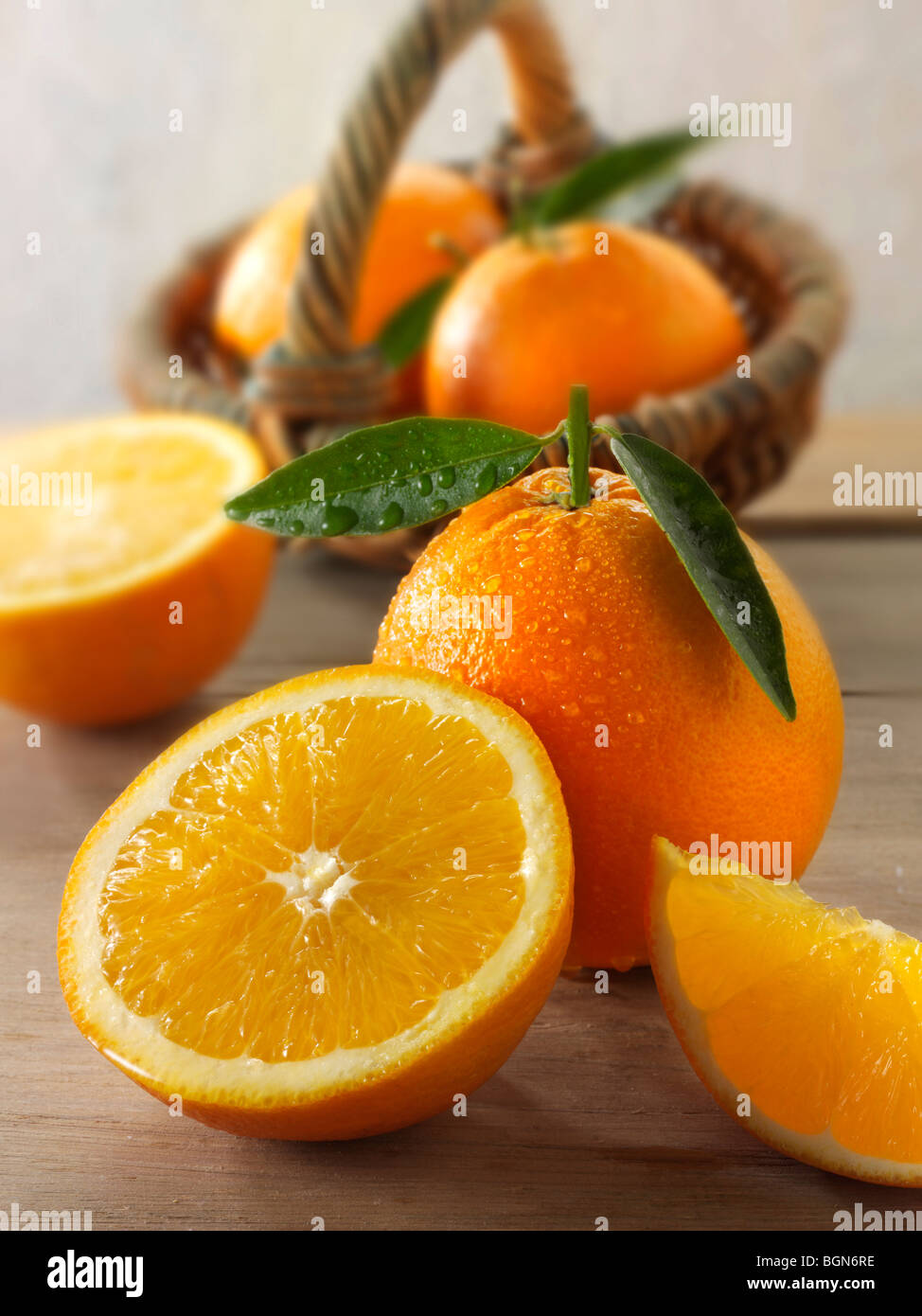 Frische Orangen ganze und geschnittene Hälften mit Blättern in einer Küche-Einstellung Stockfoto