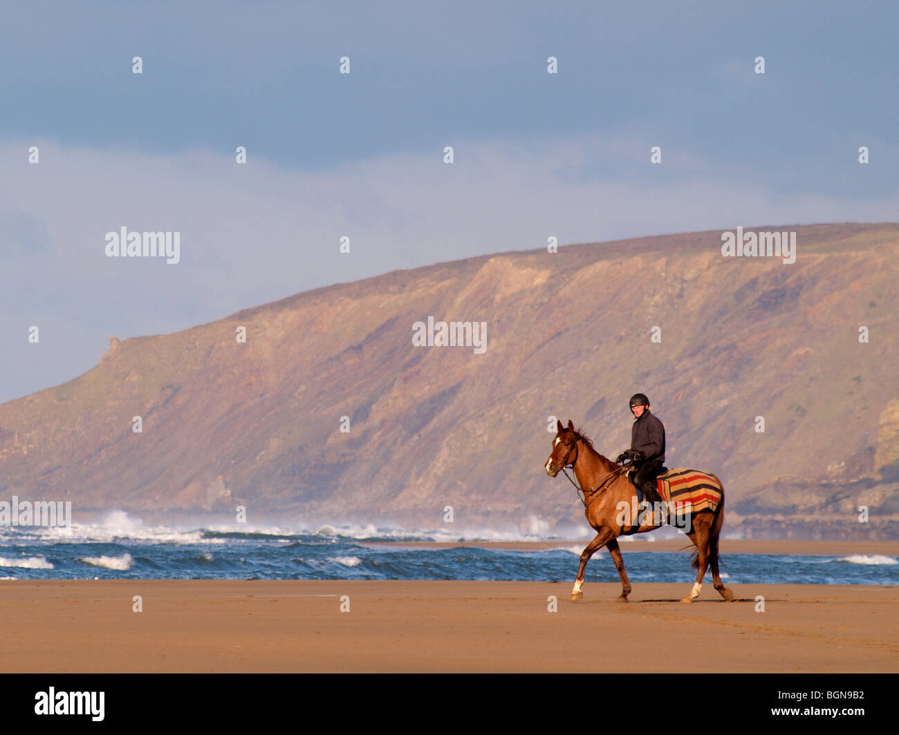 Pferd und Jockey auf dem Strand, Bude, North Cornwall. Stockfoto