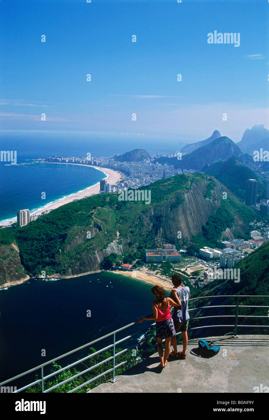 Paar bei Lookout point auf Zuckerhut oder Pao de Acucar mit Blick auf Rio De Janeiro Strände, Buchten und Berge Stockfoto
