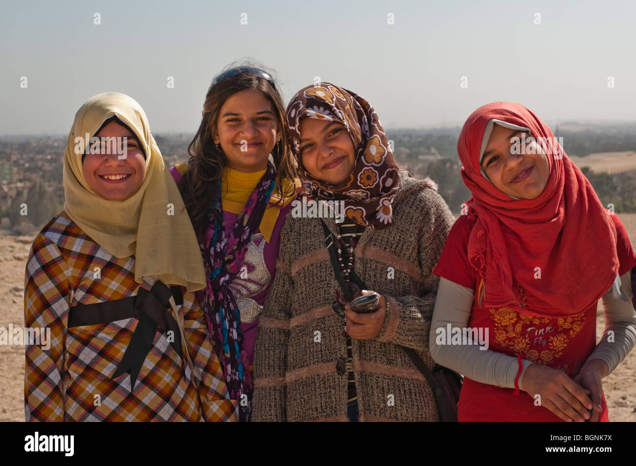 Vier schöne junge ägyptische Schulmädchen mit Kopftüchern lächelnd Stockfoto