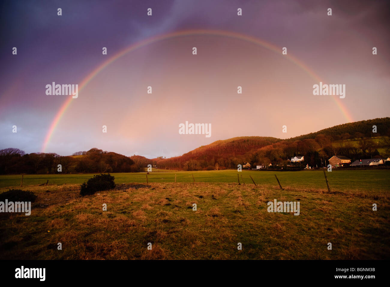 ein halb kreisförmigen Regenbogen über Feld im Westen von Wales UK Stockfoto