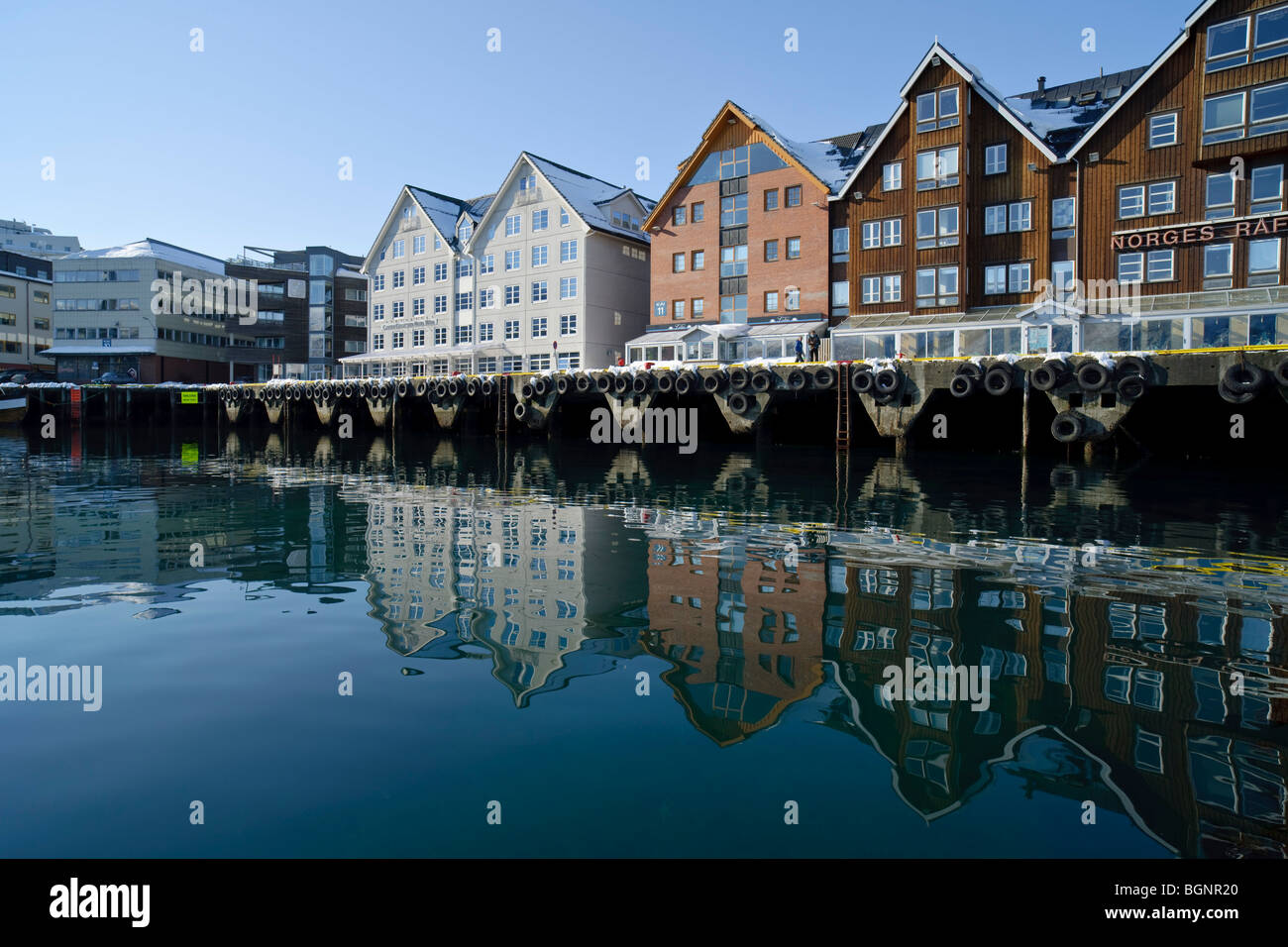 Gebäude in Tromsø Bergen reflektiert in das ruhige Meer. Tromsø, Nordnorwegen. Stockfoto