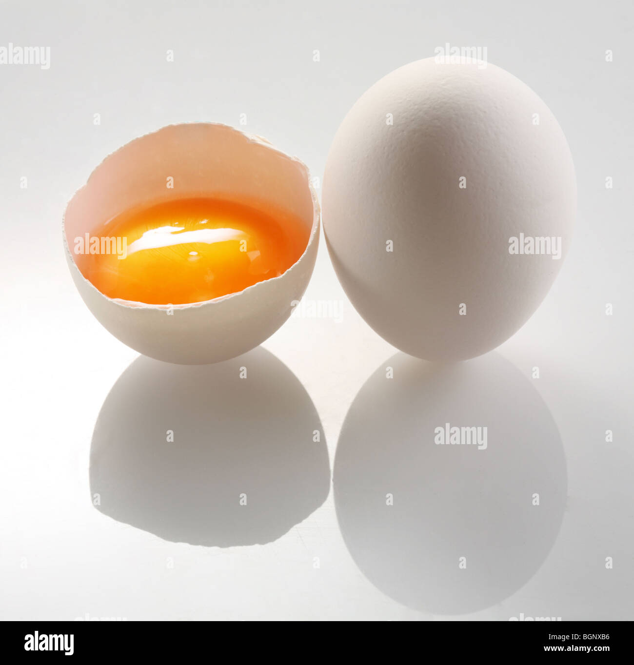 weißes Ei und einem halben Eiern auf einem weißen Hintergrund. Stockfoto