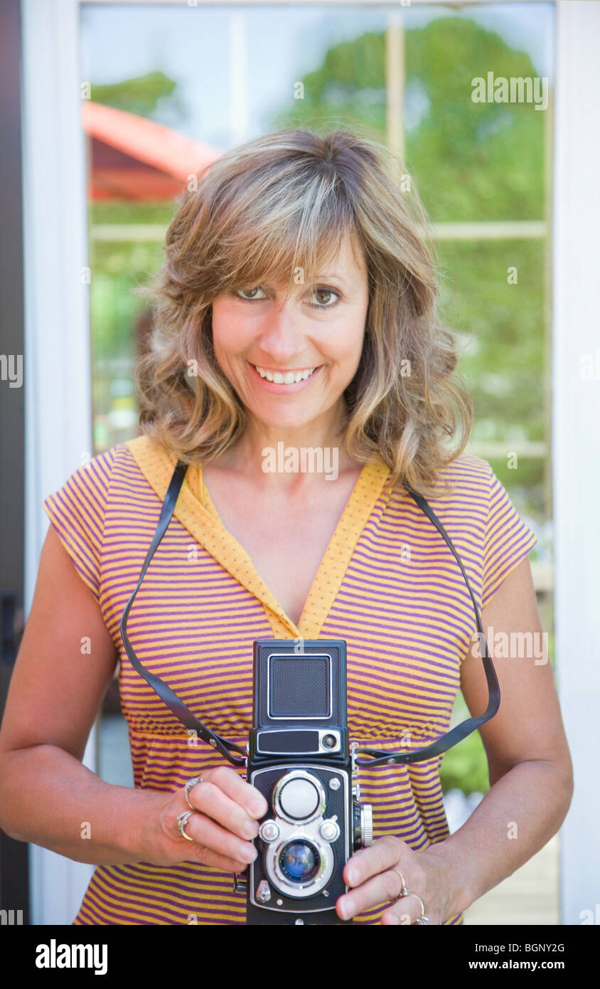 Porträt einer reifen Frau hält eine TLR-Kamera Stockfoto