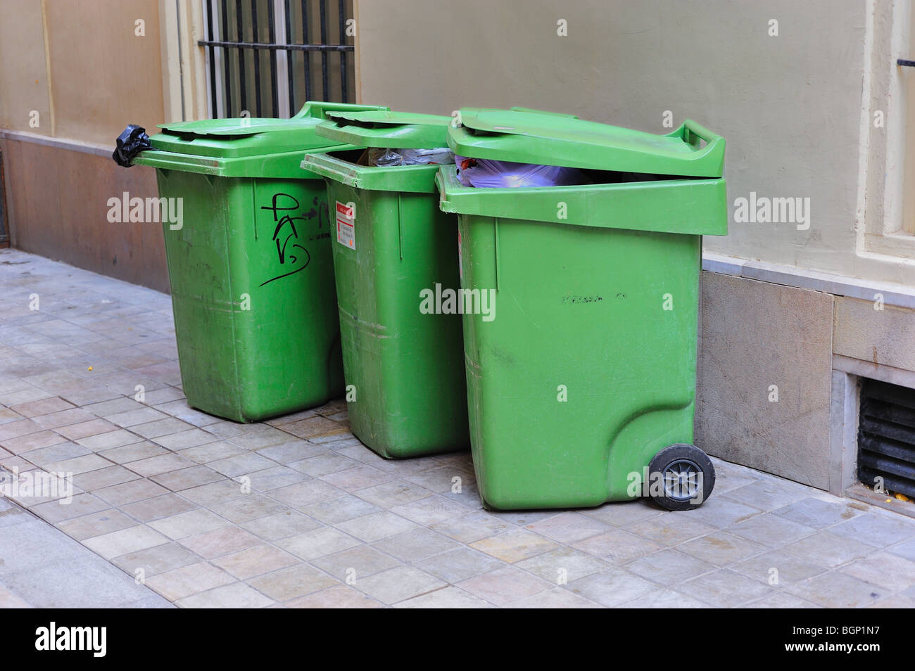 3 grüne Müllcontainer auf dem Boden Stockfoto