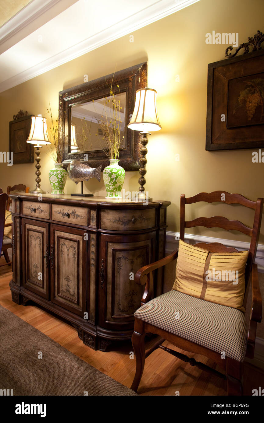 Gemalt Esszimmer Schrank auf Hartholz-Fußboden mit Stuhl auf der Seite, Lampen, Spiegel und Dekorationen Stockfoto