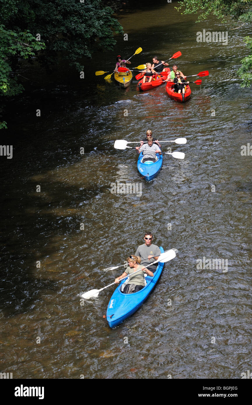 Kajakfahrer / Kanufahrer Kajak / Kanu in bunten Kajaks / Kanus auf dem Fluss Lesse in den belgischen Ardennen, Belgien Stockfoto