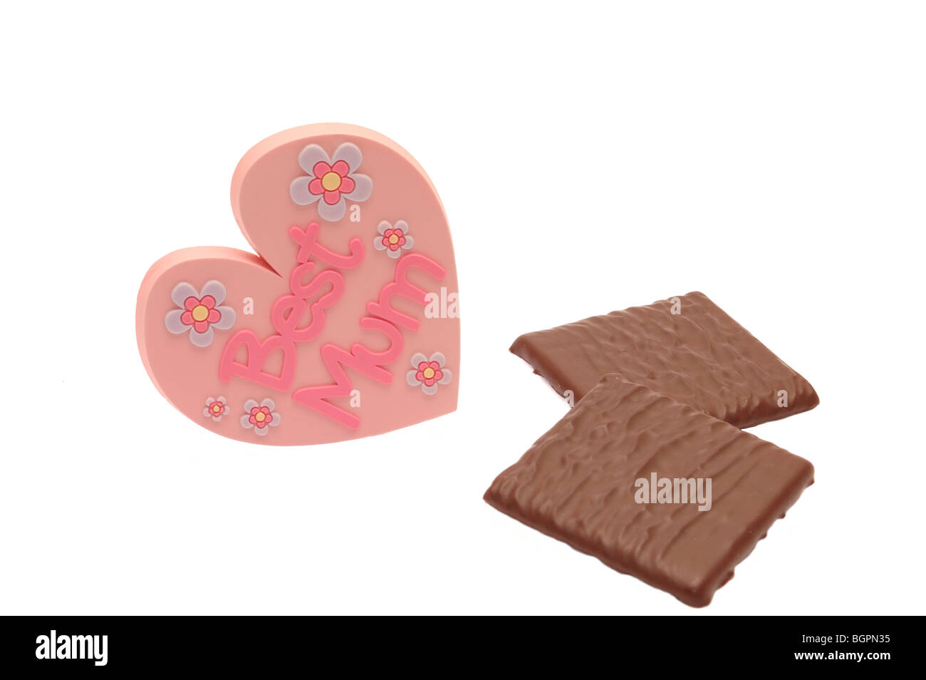 Herzförmige Mütter Tag Abzeichen zeigt beste Mama auf weißem Hintergrund mit zwei Pralinen, Ideal für Grußkarte Stockfoto