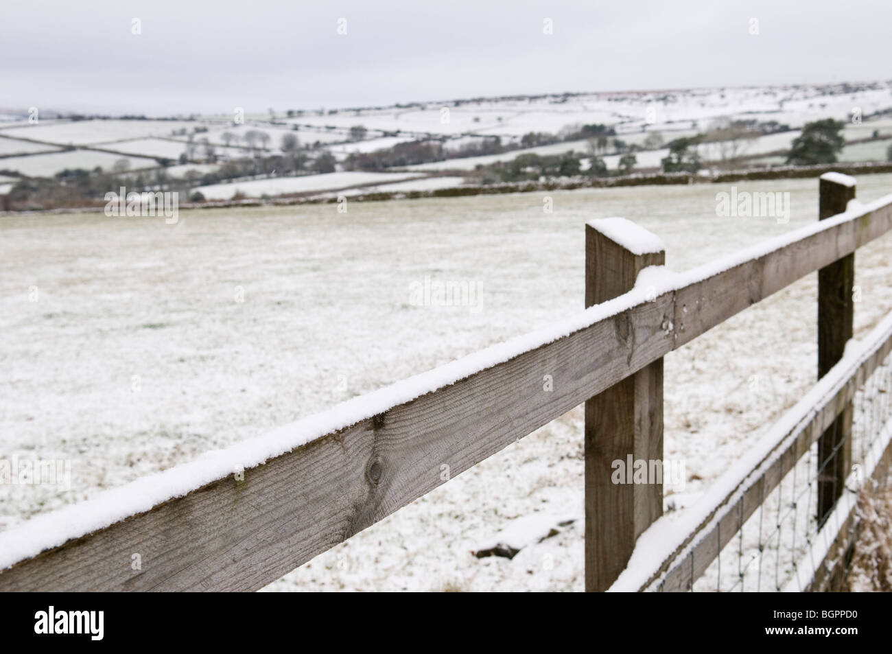 Schneebedeckte Holzzaun mit weißen Felder und Hügel, Dartmoor, Devon UK Stockfoto