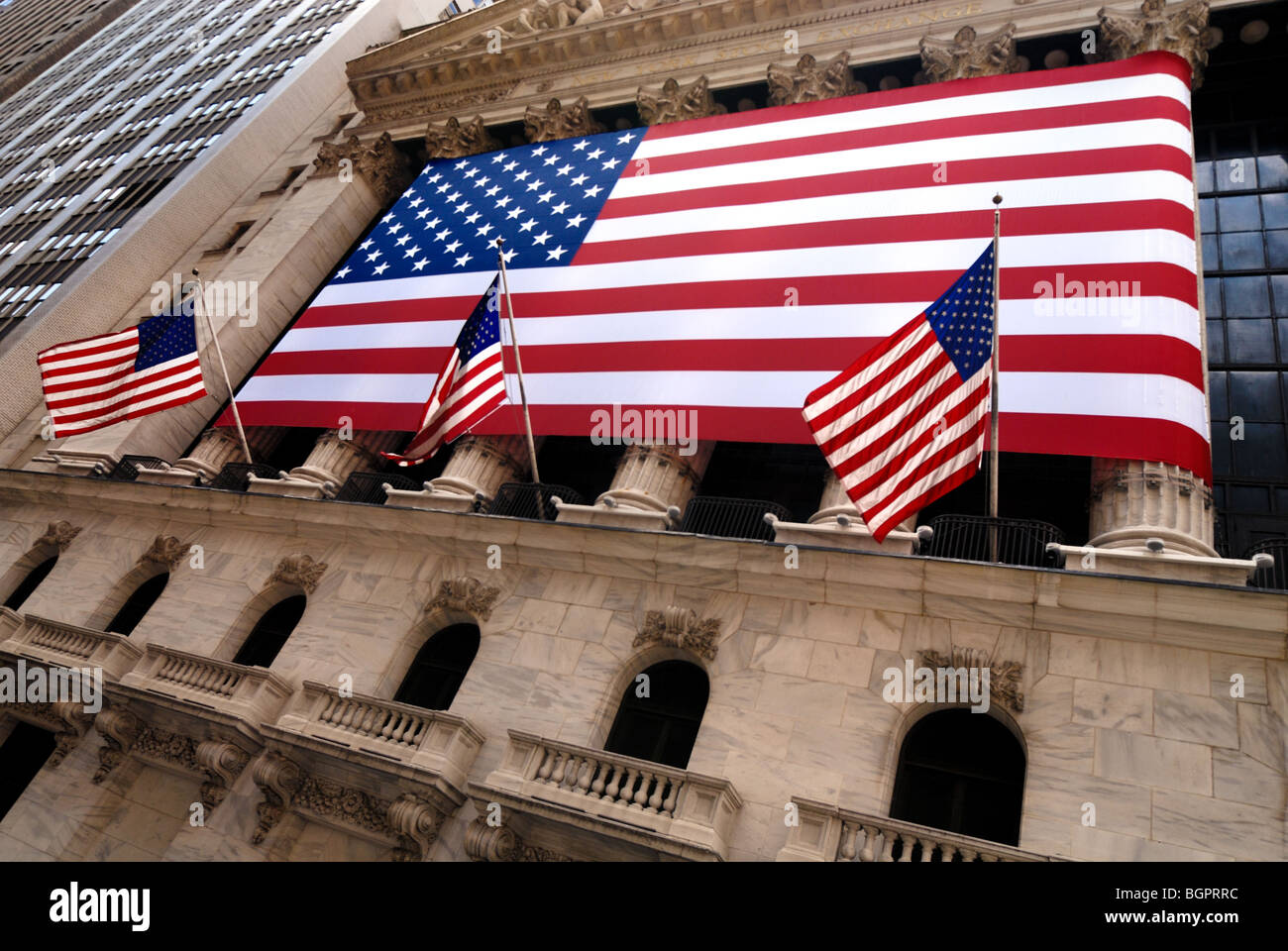 Dieser große amerikanische Flagge ist eine bekannte Sehenswürdigkeit und findet sich auf der Außenseite der New York Stock Exchange, New York, NY. Stockfoto