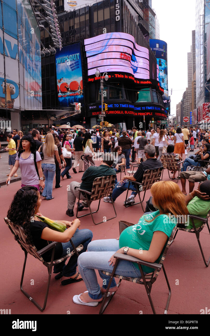 Touristen machen Sie eine Pause vom Sightseeing in den Liegestühlen, die jetzt in der gesamten Times Square vorhanden sind. Stockfoto