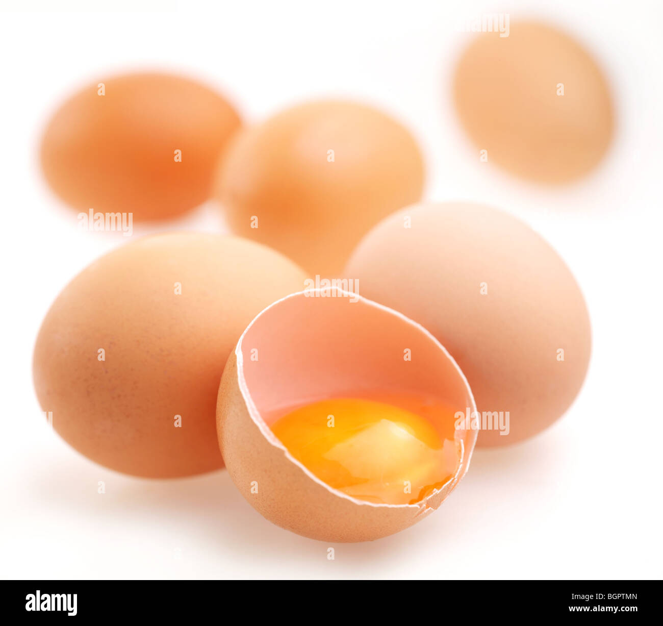 Mit braunen Eiern auf einem weißen Hintergrund. Ein Ei ist gebrochen. Stockfoto