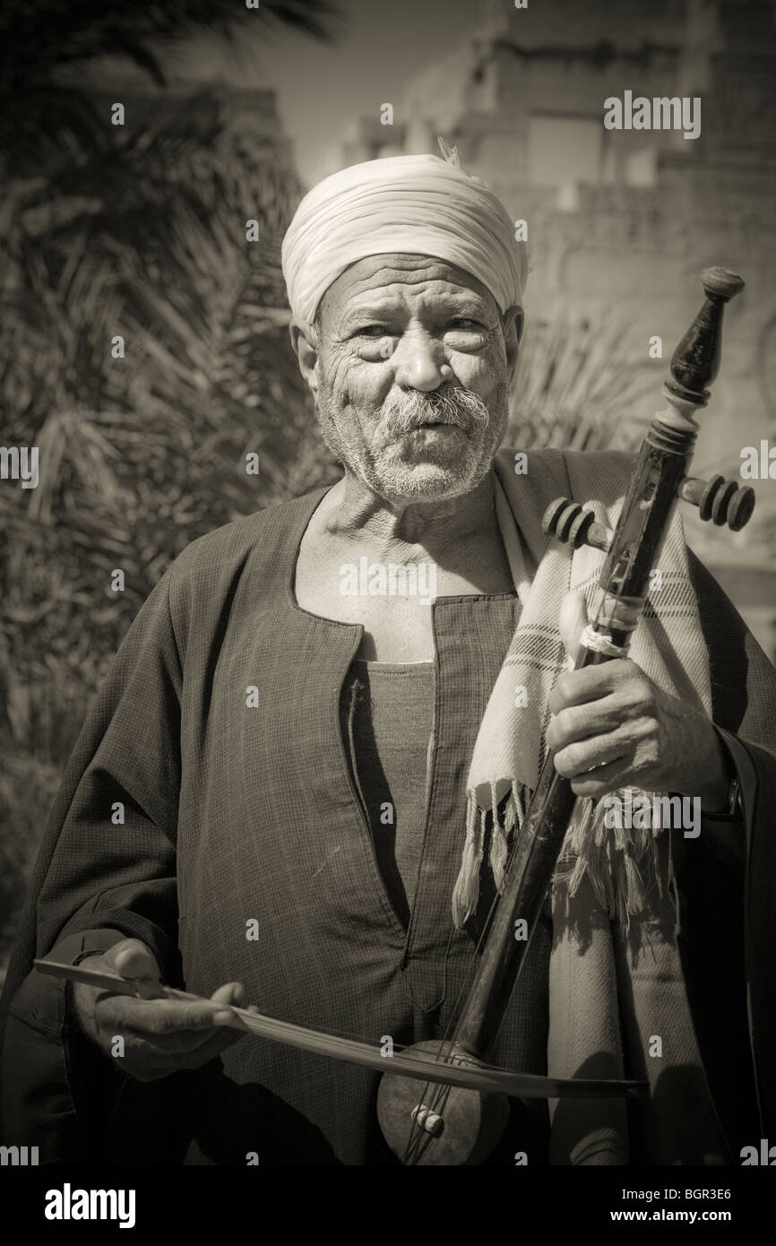 Mnotone Schuss von älteren lokalen Musiker stand vor Medinet Habu Tempel, Westbank von Luxor, Ägypten Stockfoto