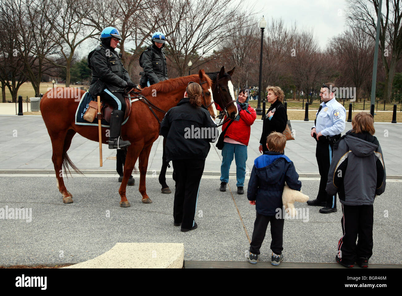 Menschen im Gespräch mit zwei berittene Polizisten auf dem Pferderücken in Washington, D.C., Hauptstadt der Vereinigten Staaten von Amerika Stockfoto
