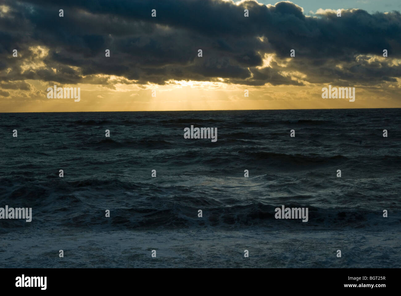 Dramatische Sonnenlicht durch Wolken an einem Wintertag in rauer See Stockfoto