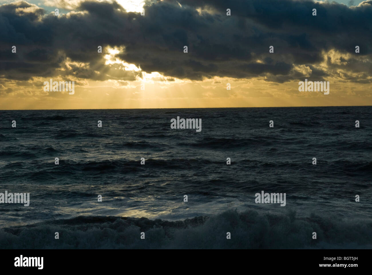 Dramatische Sonnenlicht durch Wolken an einem Wintertag in rauer See Stockfoto