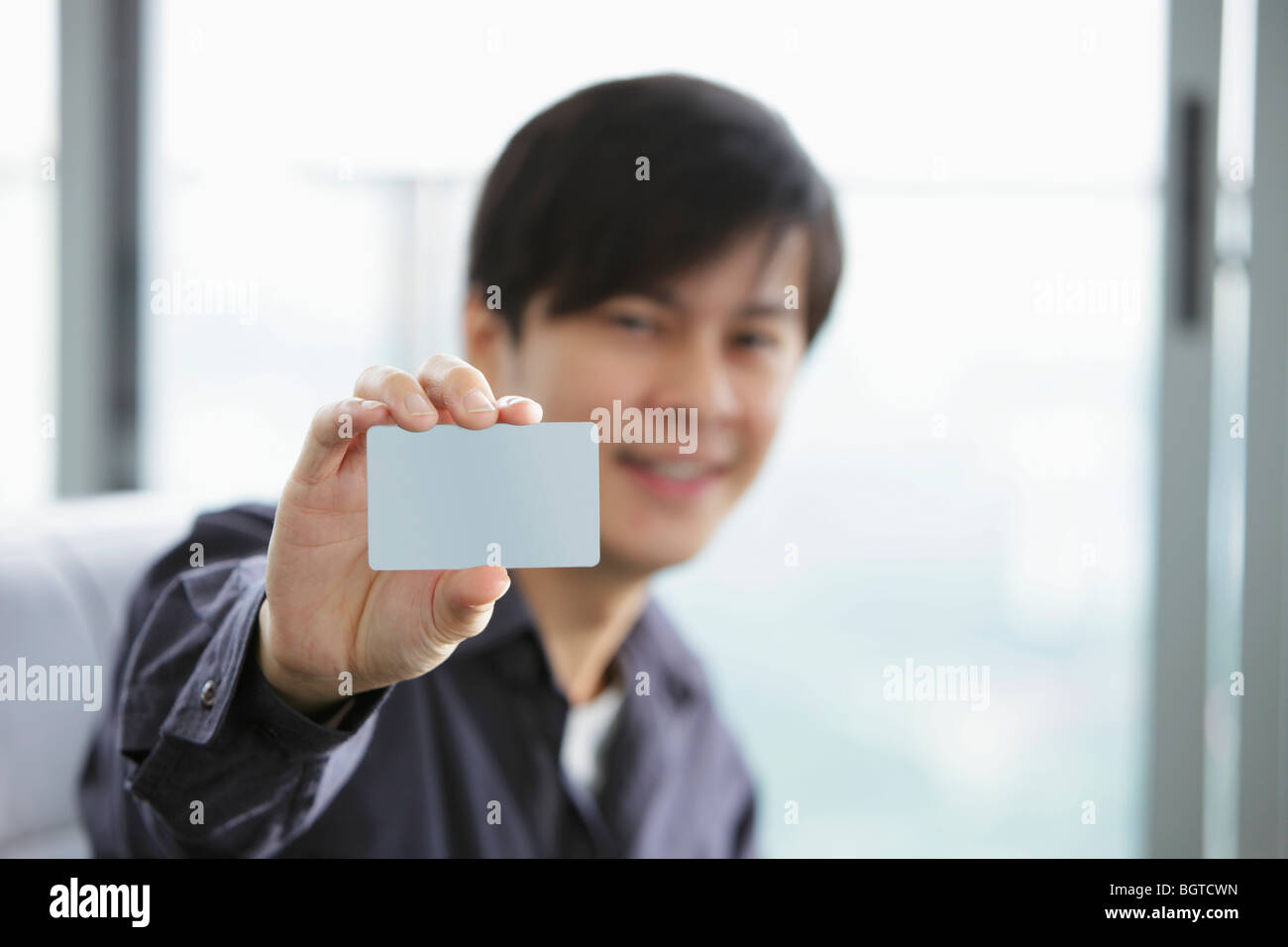 Junger Mann hält eine Kreditkarte Stockfoto