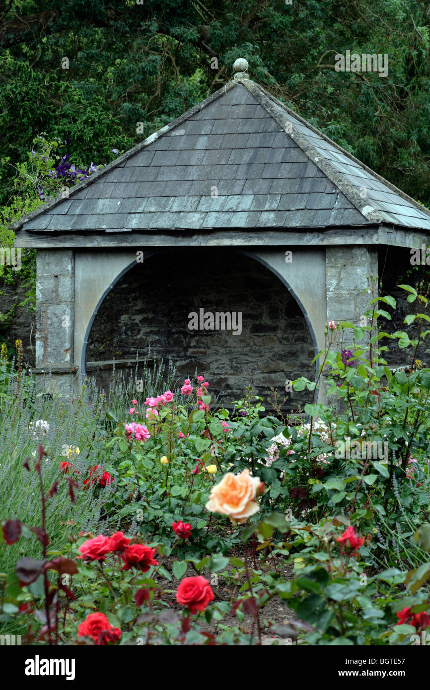Ein Stein Rückzug in eine Rose Garden. Stockfoto