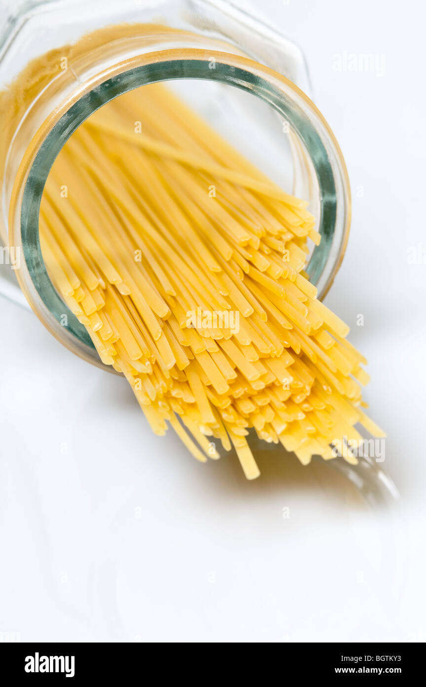 Nahaufnahme von Spaghetti getrocknete Pasta verschüttet aus einem offenen Glasbehälter Stockfoto