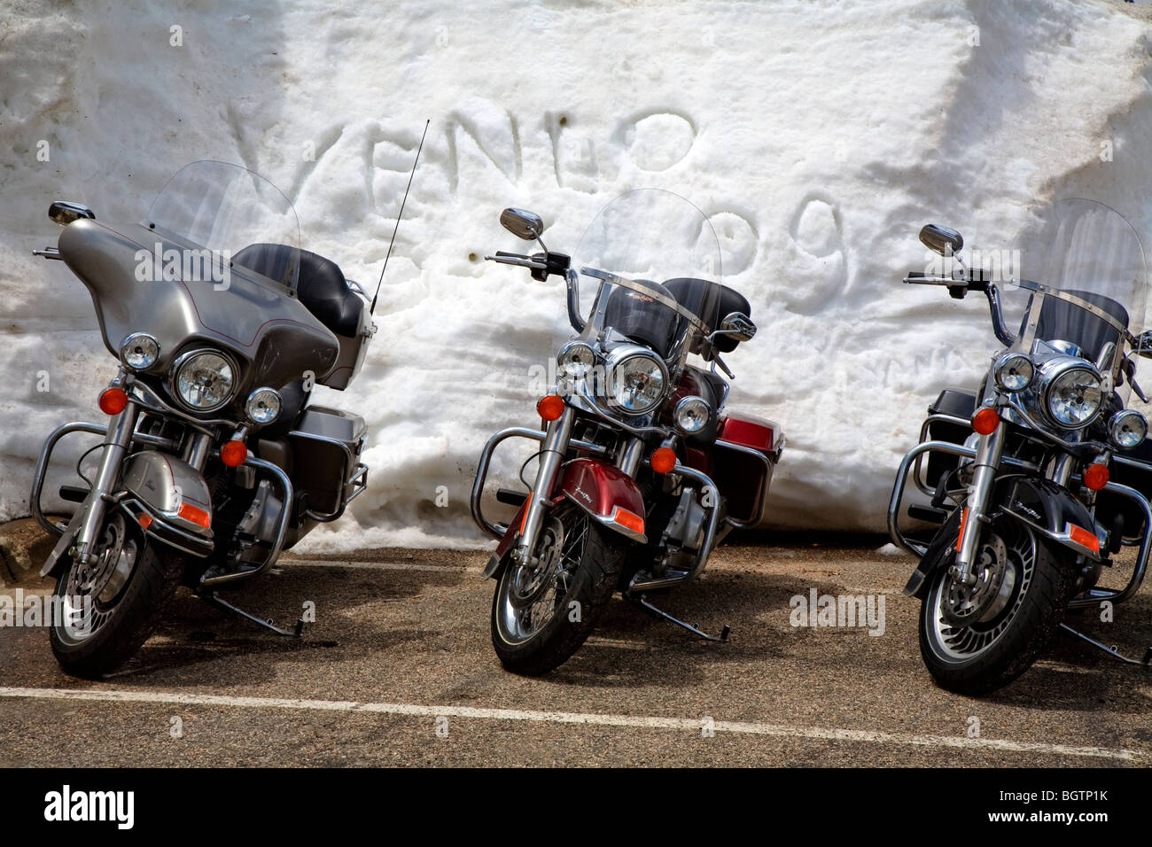 Drei Motorräder parkte vor einer Schneewehe mit dem Schreiben im Schnee, Trail Ridge Road, Rocky Mountain Nationalpark, Colorado USA Stockfoto