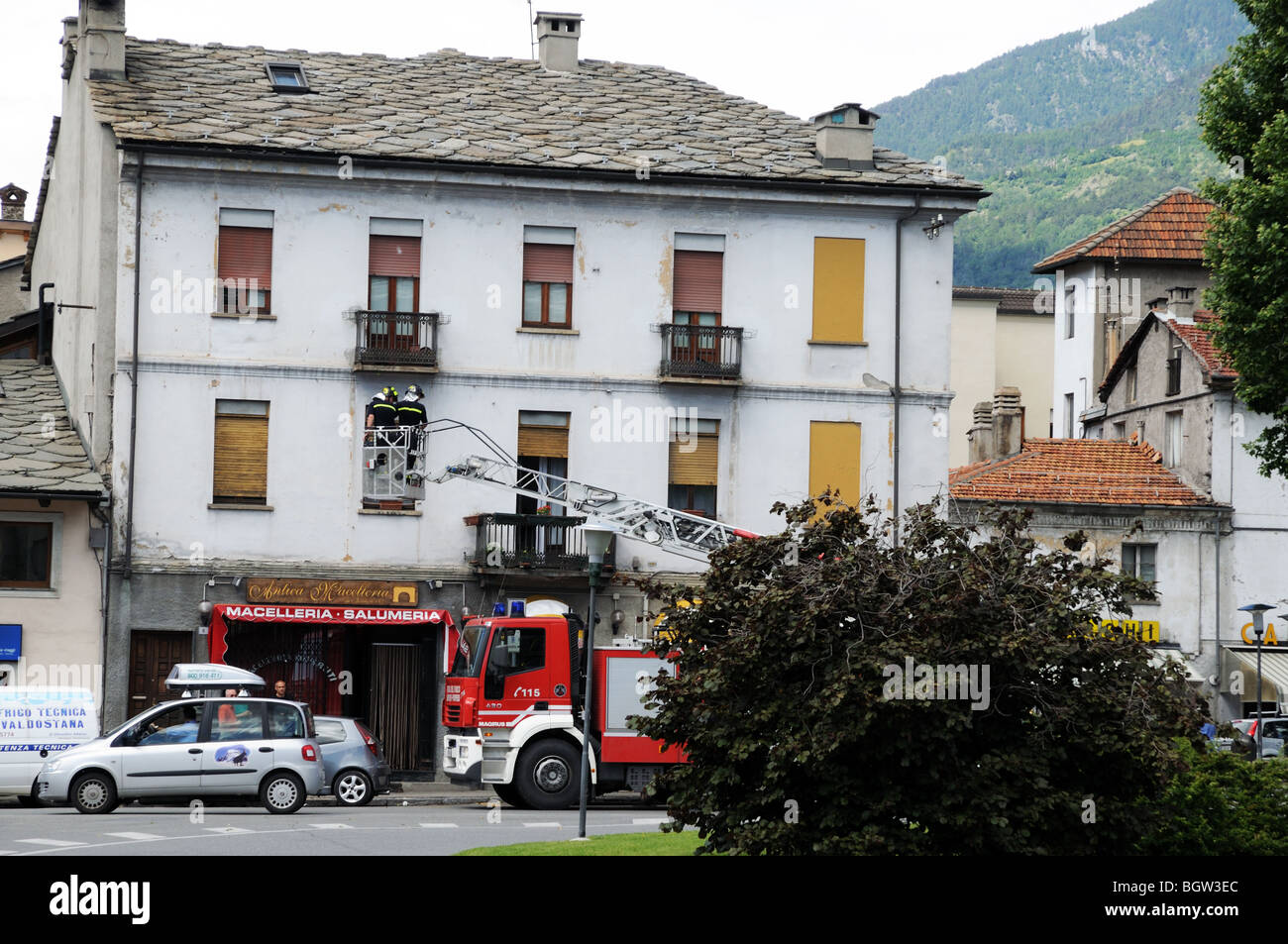 Feuerwehrauto bei inländischen Haus mit Feuerwehr in oberen Fenster über Balkon in Aosta Italien nach Hause Stockfoto