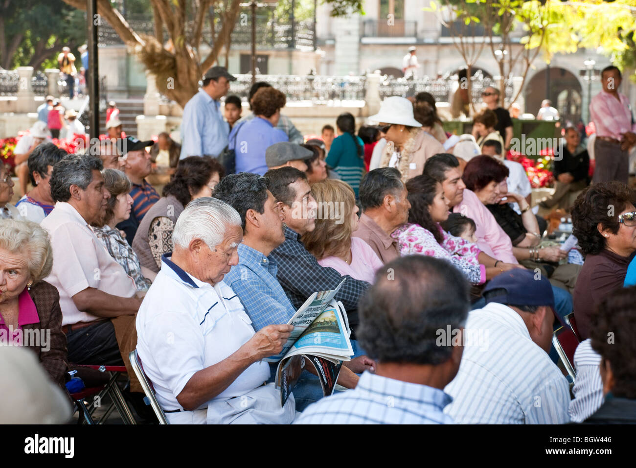 diverse & überfüllten Publikum sitzen draußen wartet geduldig auf ein Sonntagskonzert im historischen Oaxaca City Zocalo Mexiko beginnen Stockfoto
