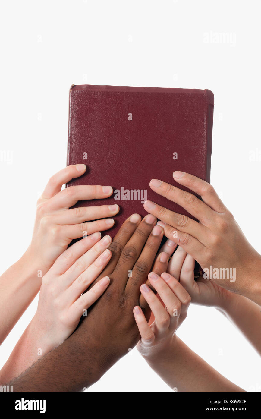 Interracial Hände hochhalten einer Bibel Stockfoto