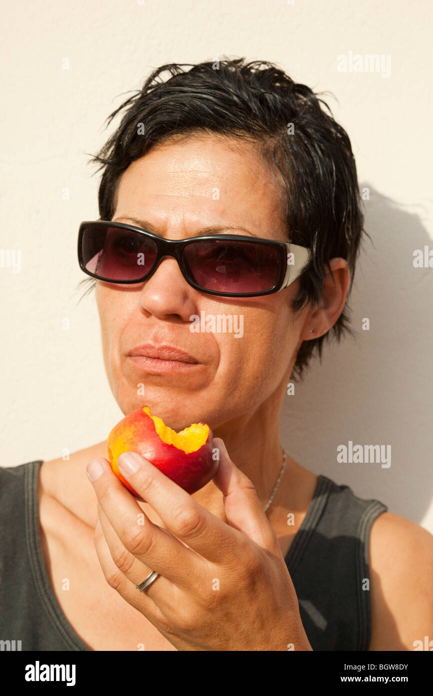 Frau, Essen einen Pfirsich Stockfoto