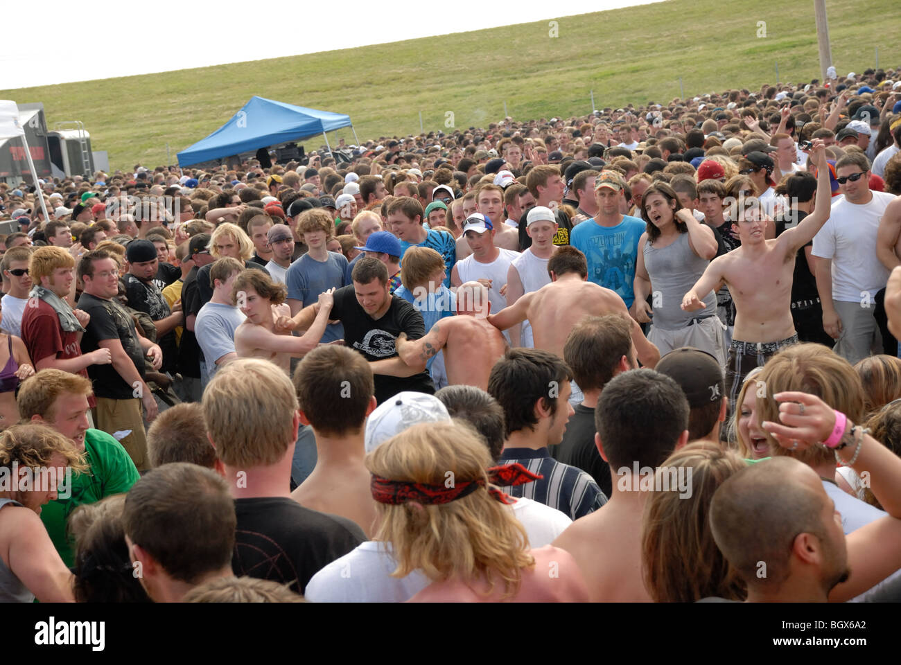 Eine große Menschenmenge bei einem Rockkonzert statt an einem freien Ort, mit Kreis-Grube oder Moshpit in Mitte der Masse. Stockfoto