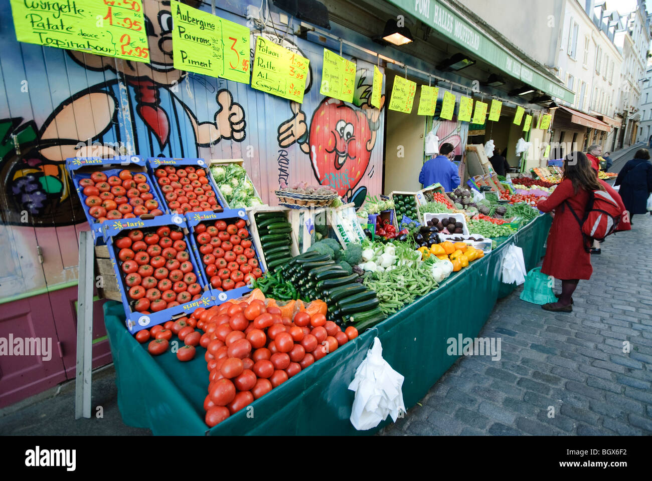 PARIS, Frankreich – Ein lebhafter Pariser Freiluftmarkt bietet eine große Auswahl an frischen Produkten. Farbenfrohe Obst- und Gemüseszene werden an verschiedenen Verkaufsständen kunstvoll arrangiert, während lokale Händler und Käufer in dieser traditionellen französischen Marktplatzszene interagieren. Stockfoto