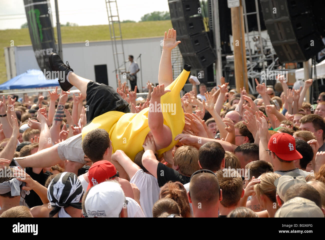 Ein Teenager in einem Banane-Anzug sein Publikum bei einem Rockkonzert gesurft. Stockfoto