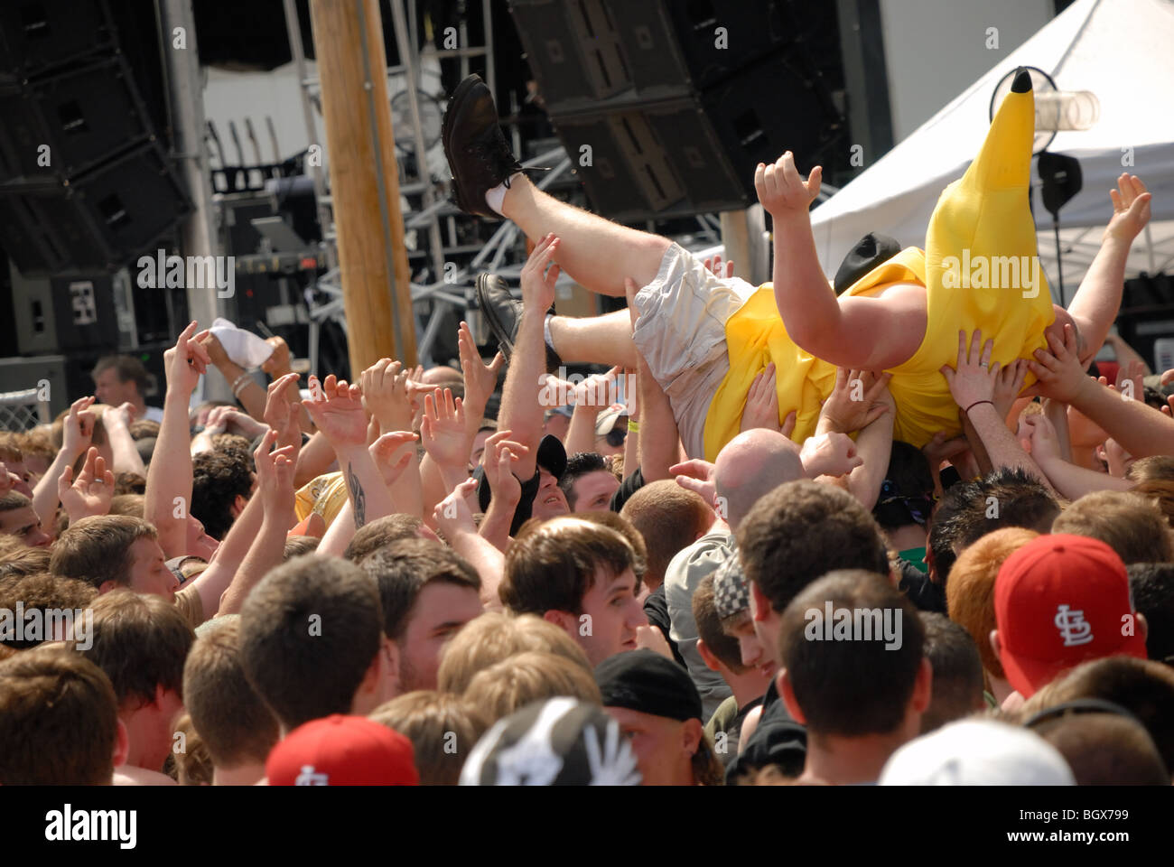 Ein Teenager in einem Banane-Anzug sein Publikum bei einem Rockkonzert gesurft. Stockfoto