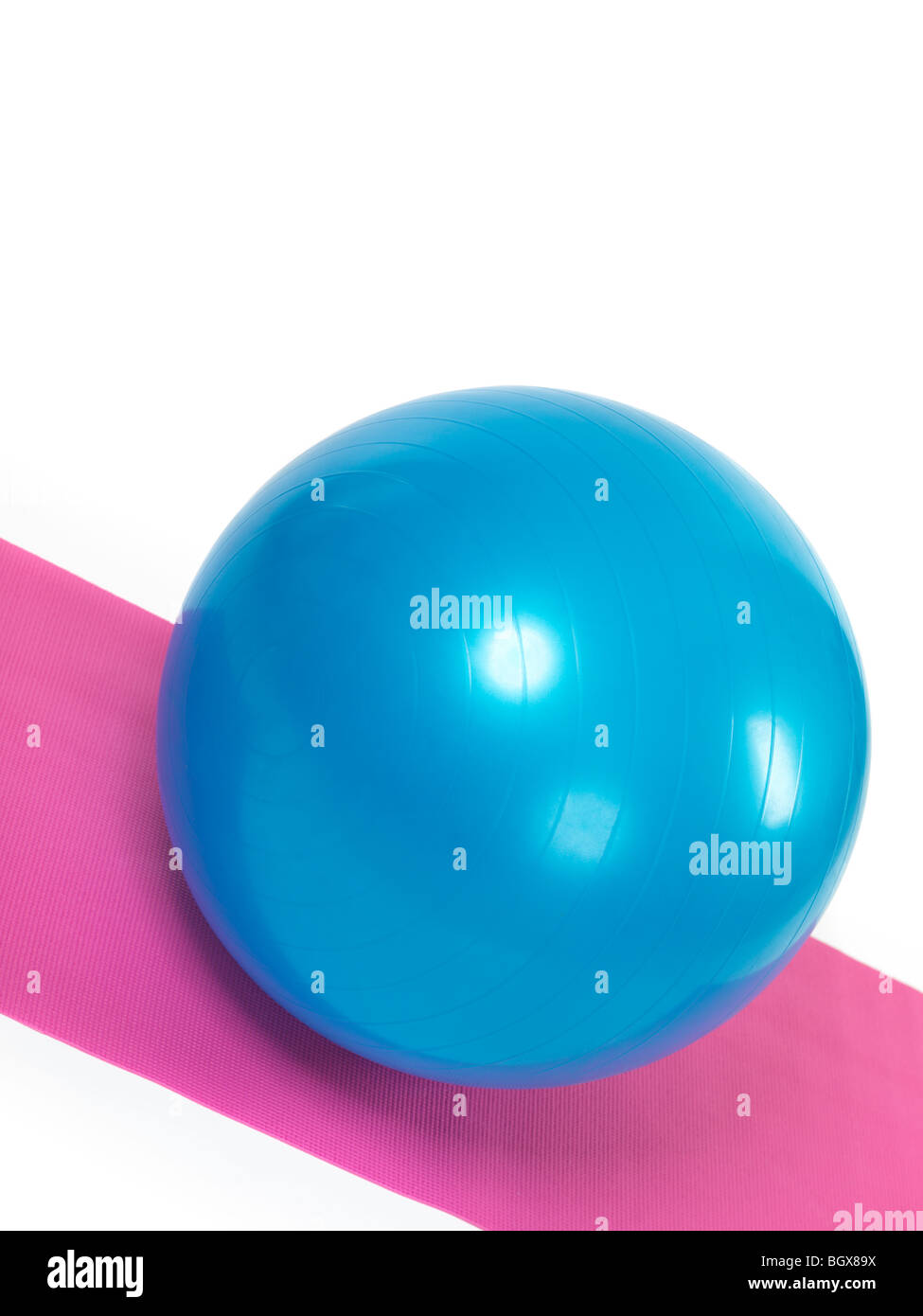 Blaue Fitnessball auf lila Matte isoliert auf weißem Hintergrund Stockfoto