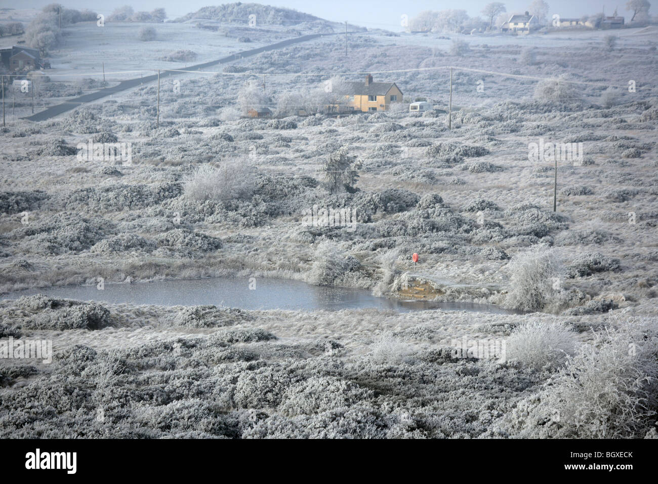 Eine Winterlandschaft mit abgelegene Häuser auf Halkyn Berg in der Nähe von Rhosesmor Nord-Wales. Stockfoto