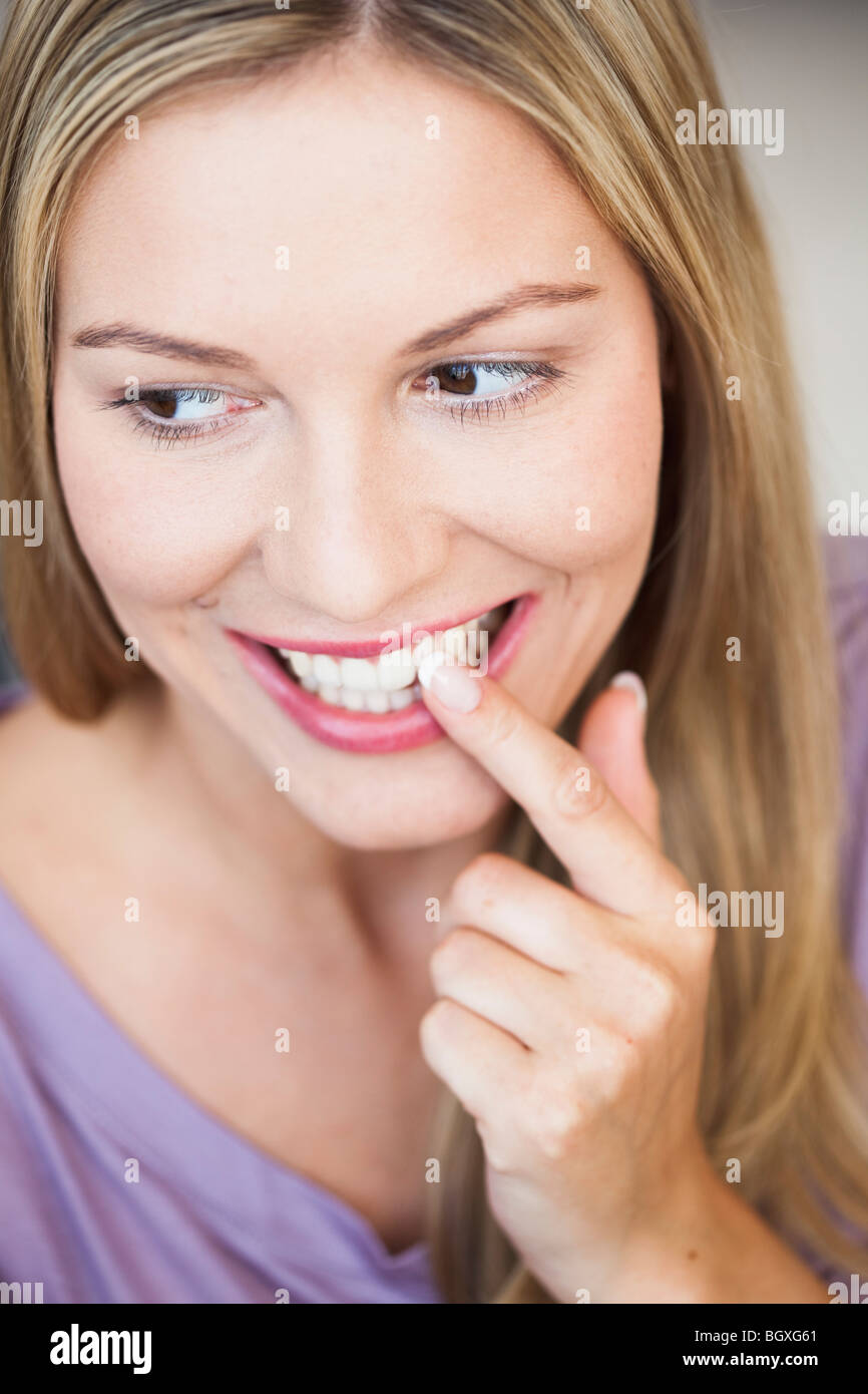 Junge Frau zeigt auf ihre Zähne Stockfoto