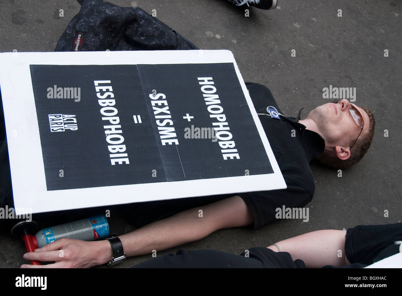 Paris, Frankreich - Gay Rights Aktivists of Act up-Paris protestieren gegen Homophobie, Mann, der auf Gehsteig IDAHOT gegen Sexismus, Lesbophobie legt Stockfoto