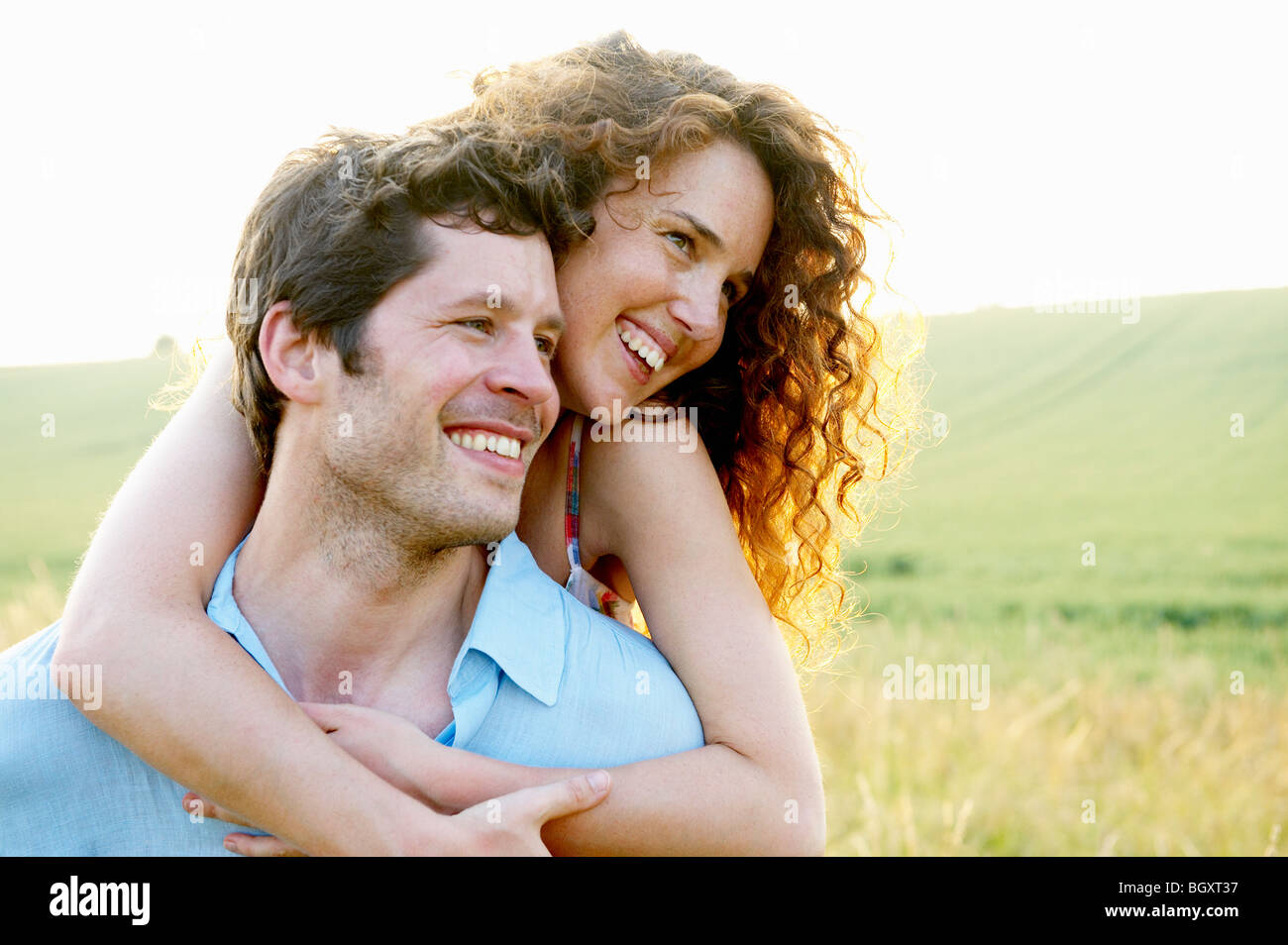 Mann trägt Frau in einem Weizenfeld Stockfoto