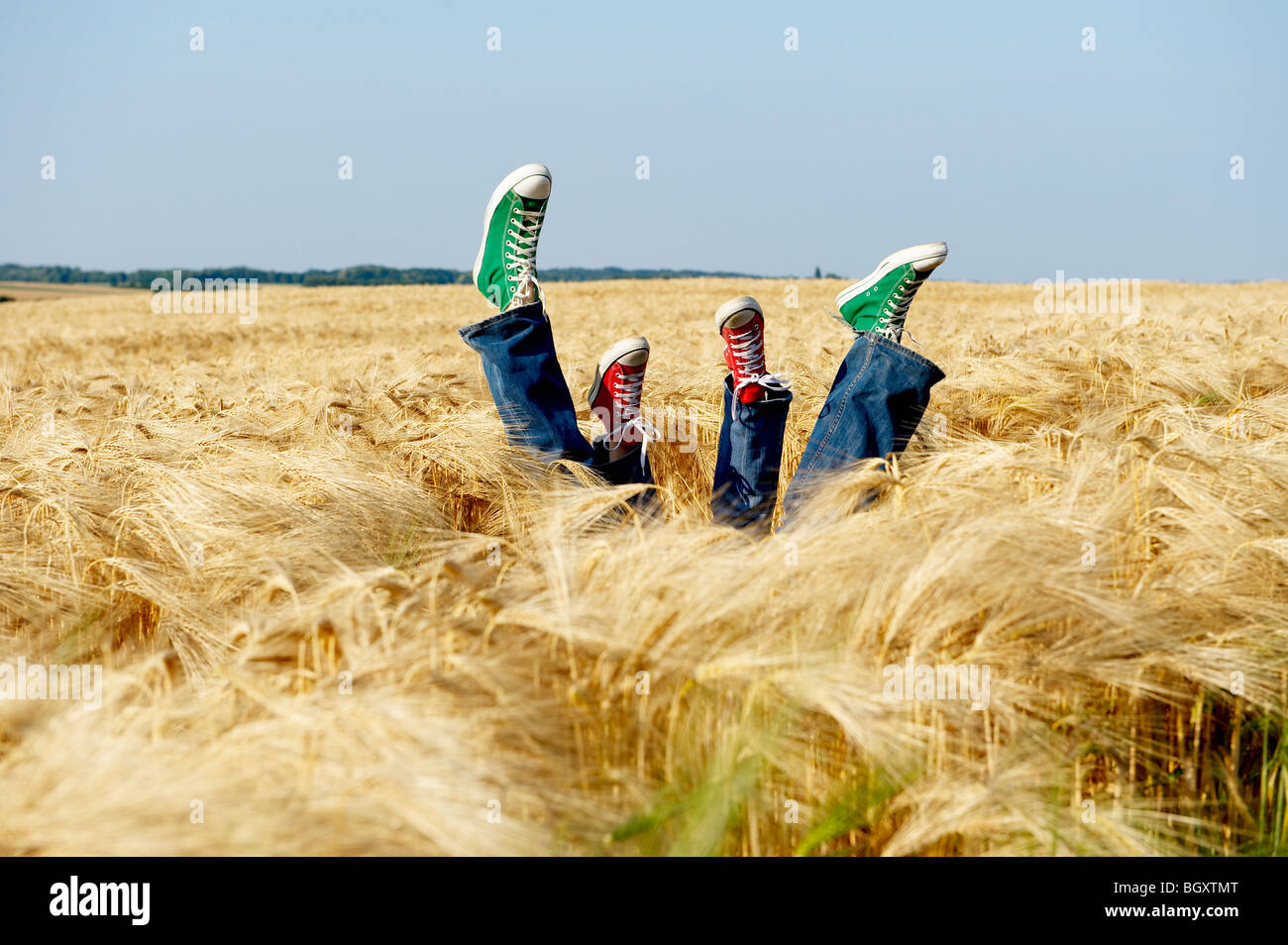 Füße heben sich aus einem Weizenfeld Stockfoto