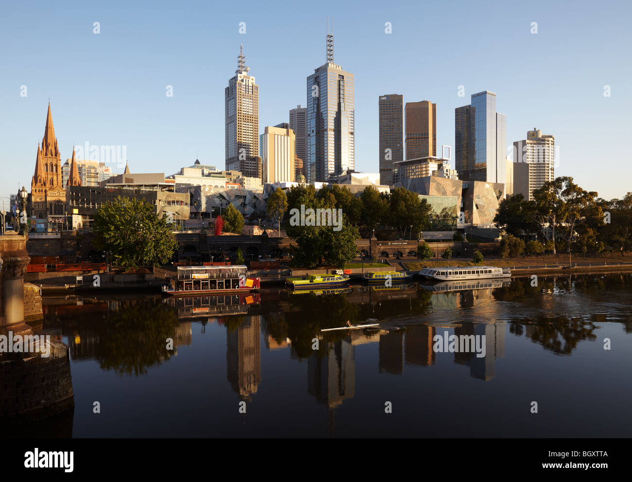 Ein Ruderer am frühen Morgen auf dem Yarra Fluss und die Stadt Skyline im Morgengrauen Melbourne, Victoria, Australia Stockfoto