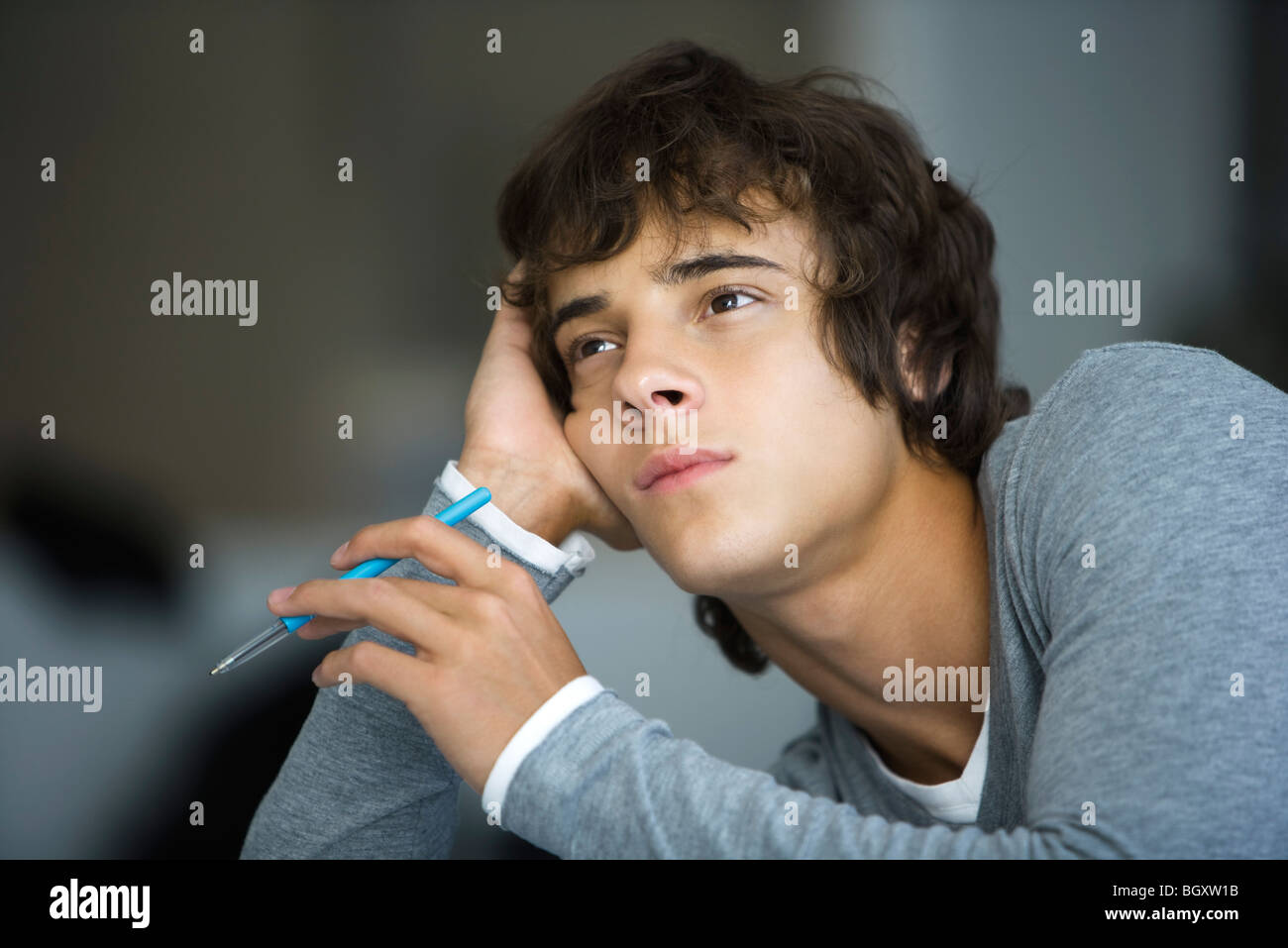 Junger Mann stützte sich auf Ellbogen untätig wegschauen Stockfoto