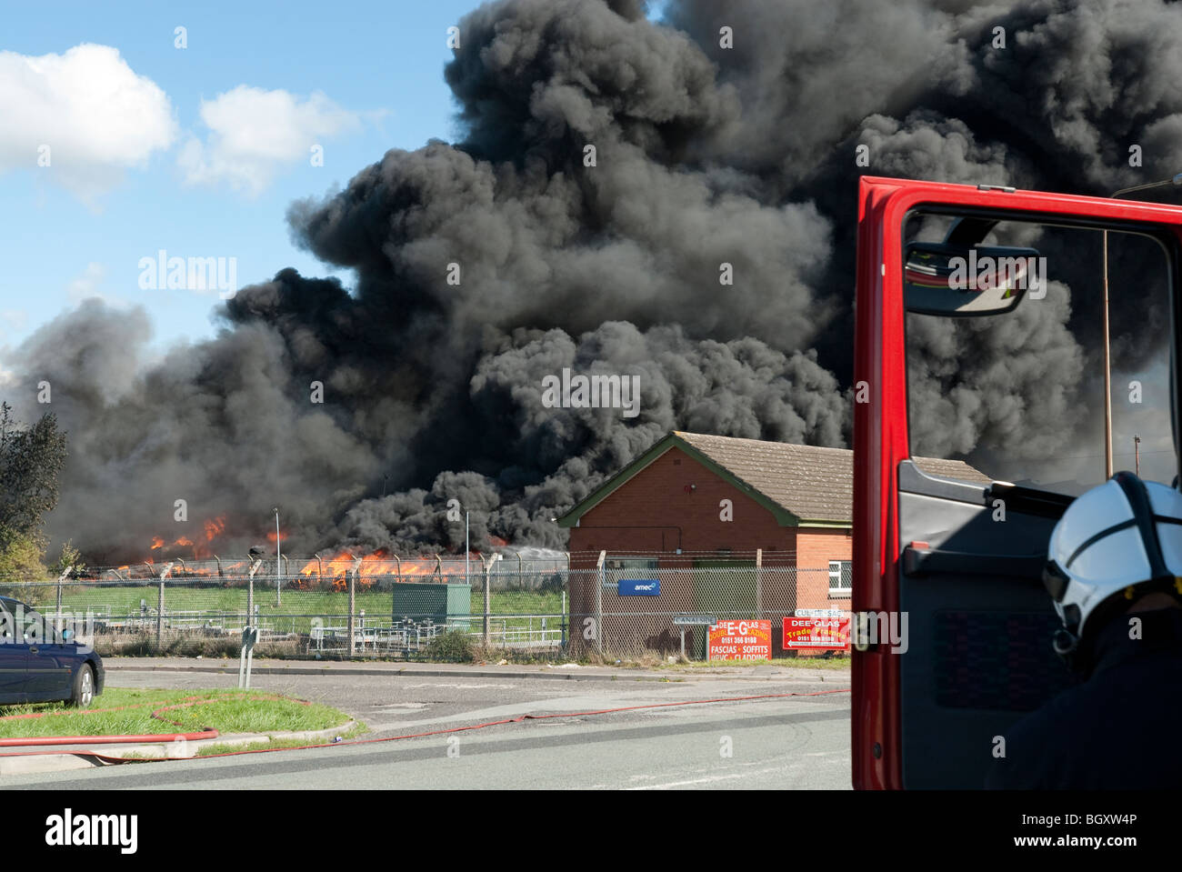 Große industrielle Feuer mit großen Federn von dicken schwarzen Rauch gegen blauen Himmel voll Modell veröffentlicht Stockfoto