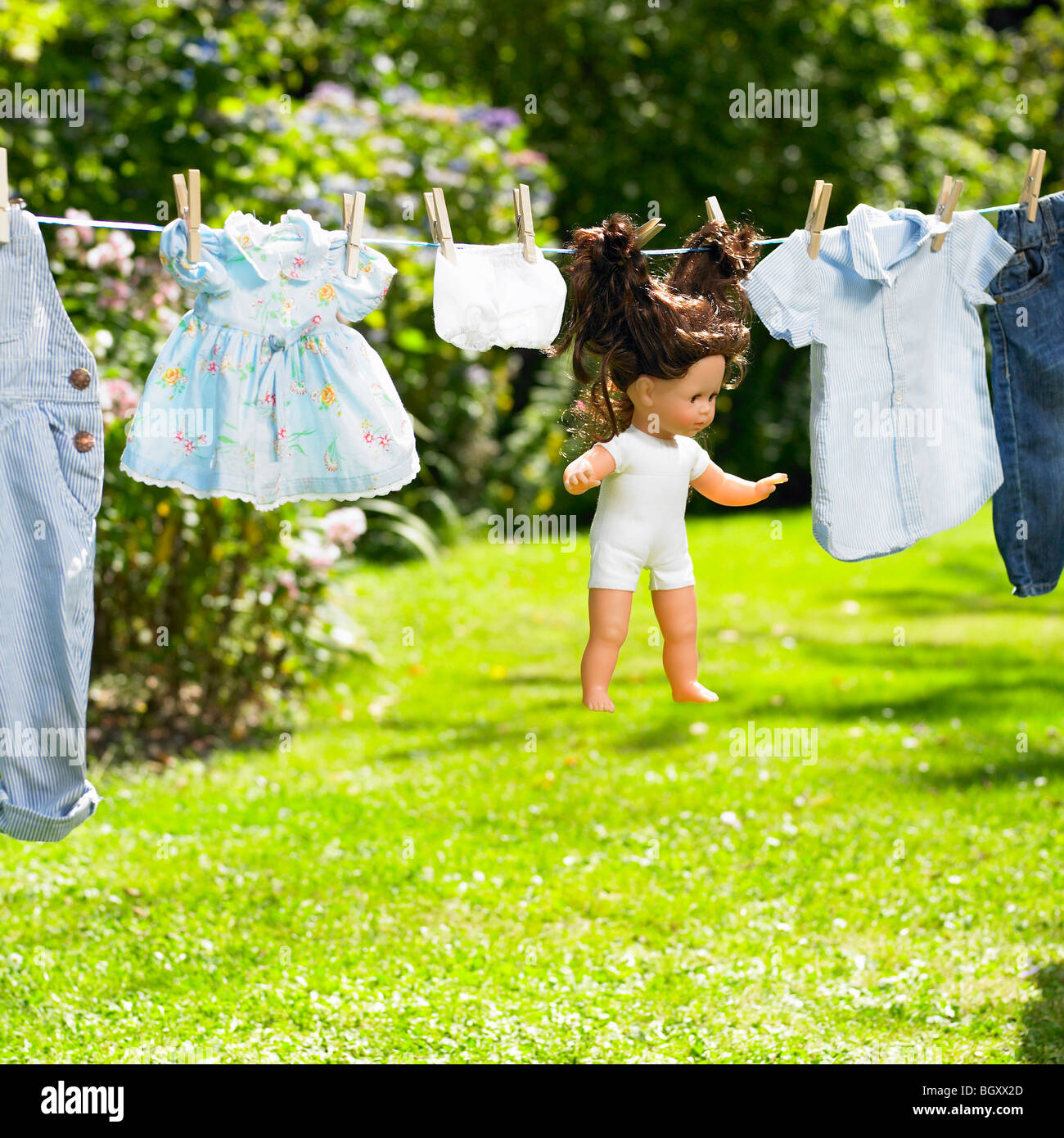 Puppe und seine Kleidung auf einer Wäscheleine Stockfoto