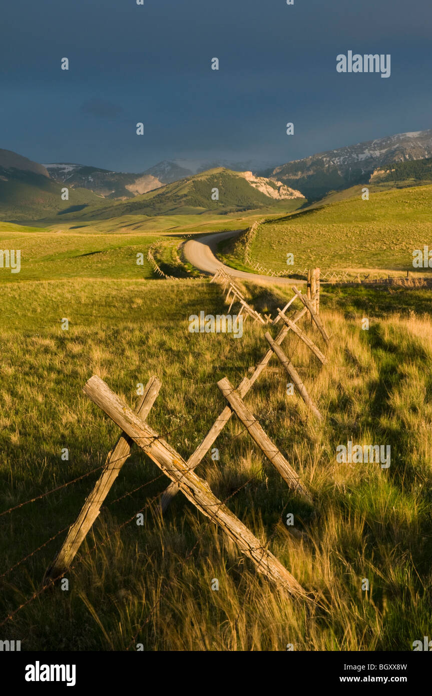Jack-Zaun und Straßen- und Bergen bei Sonnenaufgang-Rocky Mountain Front, Montana Stockfoto