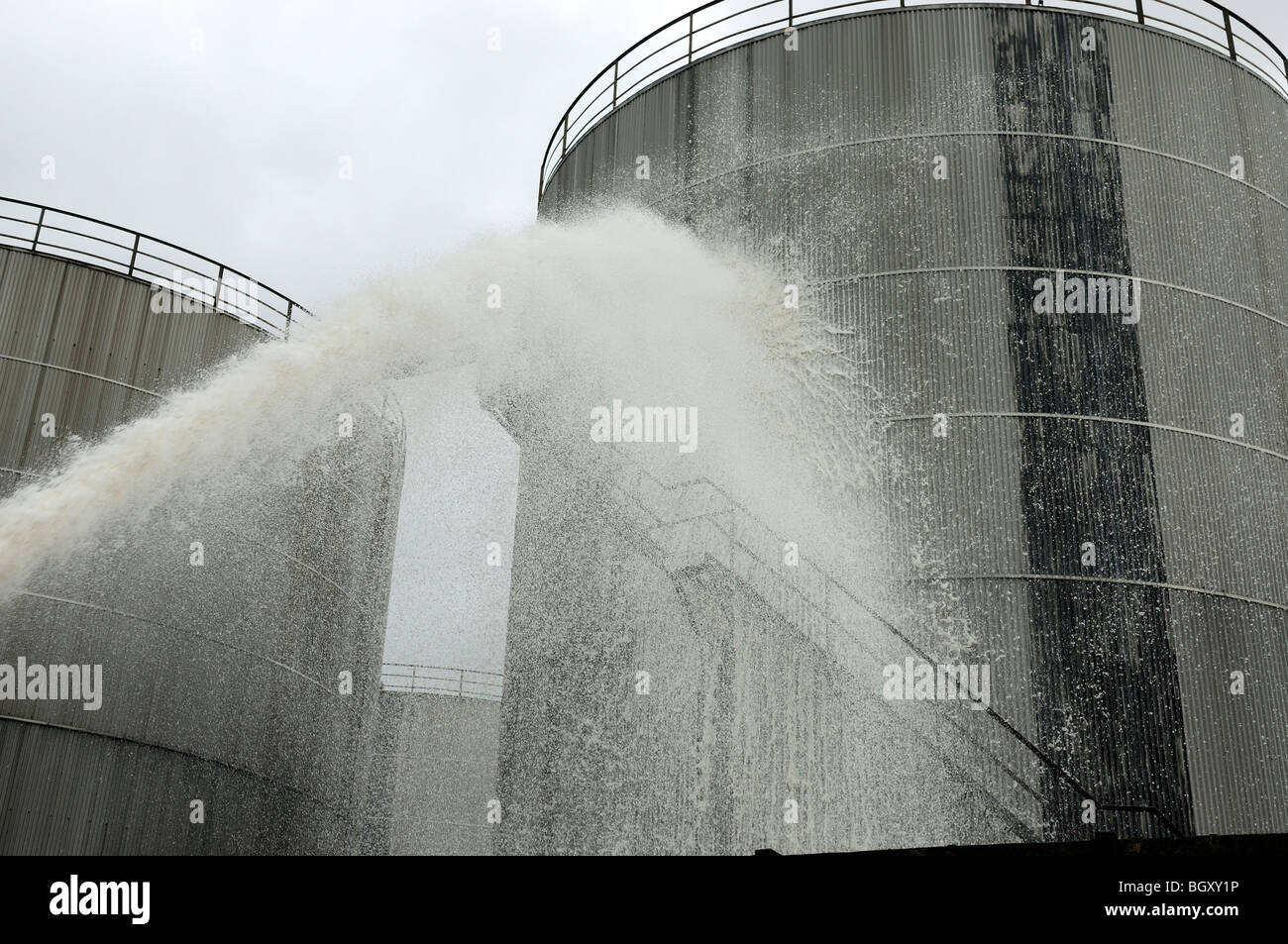 Feuerwehr sprühen Leichtschaum auf Öltank im depot Stockfoto